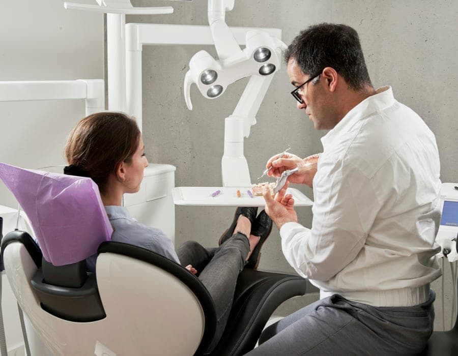 Dentista realizando um procedimento em detalhe na boca de um paciente