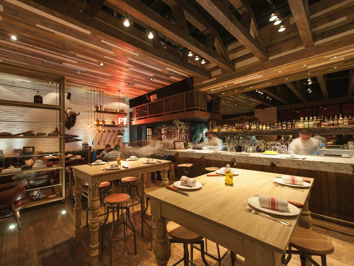 Mesas e cadeiras de madeira no salão de um pequeno restaurante italiano