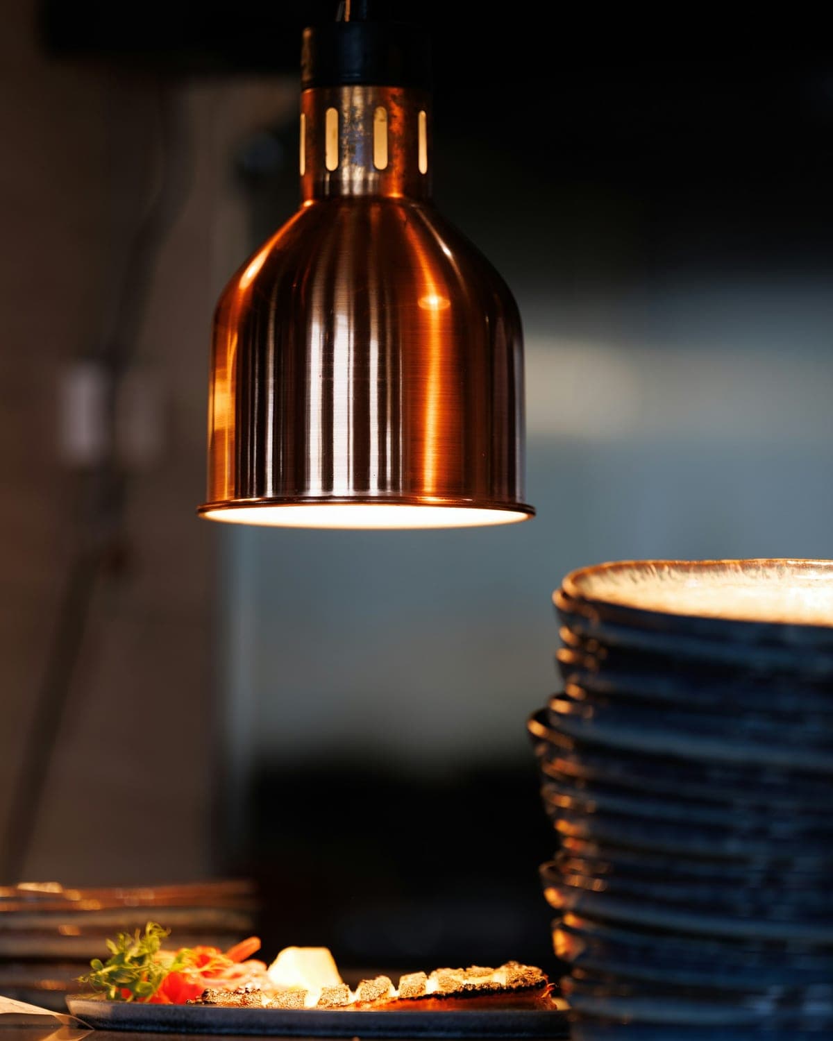 Luminária de cobre aquecendo pães sobre o balcão do restaurante