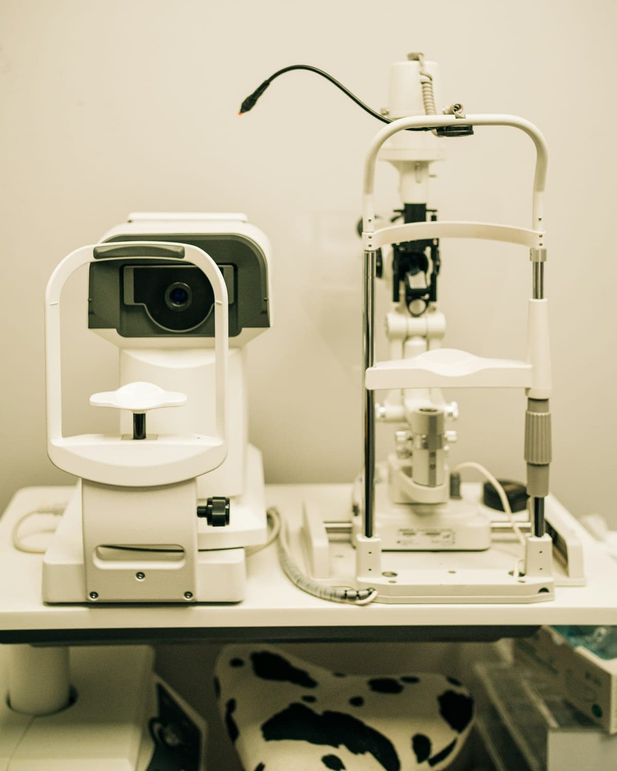 Microscópio oftalmológico branco sobre uma bancada de atendimento